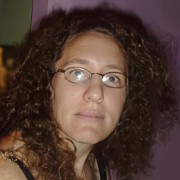 Woman with long dark curly hair and glasses